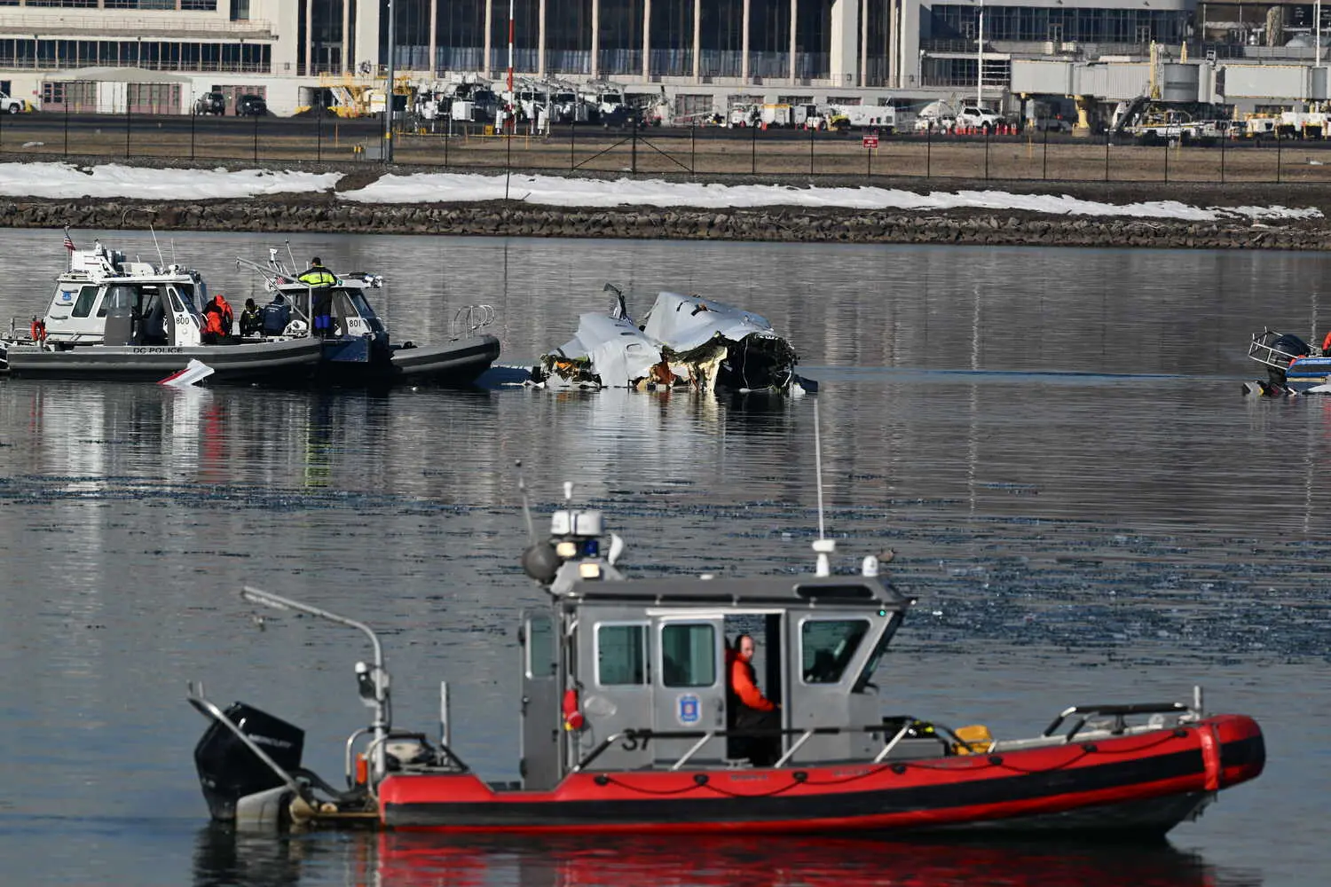 Співробітники служби надзвичайних ситуацій досліджують уламки в річці Потомак, коли світало в четвер.